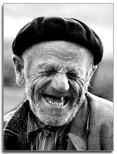 an old man with a hat and tie on his head is smiling at the camera