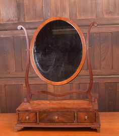 an old wooden table with a mirror on it