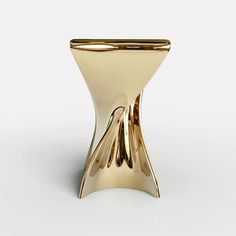 a gold vase sitting on top of a white table