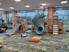 children's play area in an office building with slides and climbing equipment on the floor