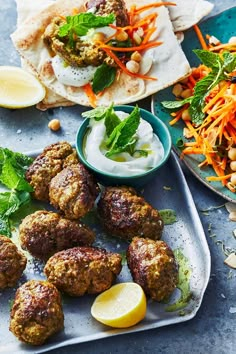 some meatballs are on a plate with carrots and lettuce next to it