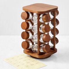 a wooden wine rack with several bottles in it and a paper on the floor next to it