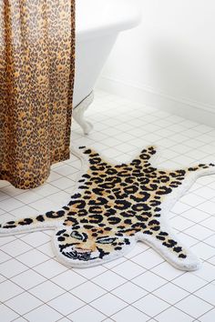 a leopard print rug is on the floor next to a bathtub