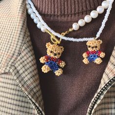 a person wearing a necklace with a teddy bear on it