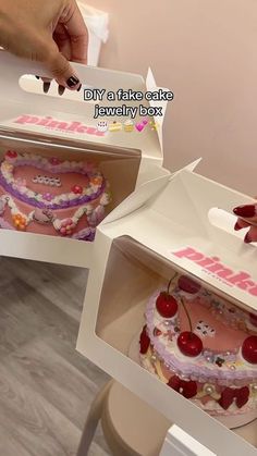 two cakes in boxes with cherry toppings on the top and one cake inside it