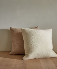 two pillows sitting on top of a wooden floor