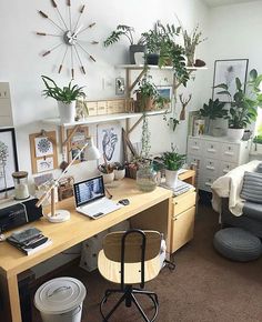 a home office with plants on the desk