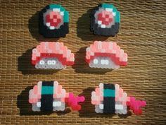 four pieces of pixel art made to look like sushi rolls on a woven mat