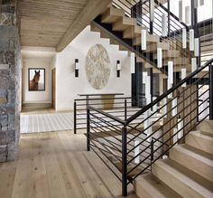 a staircase in a house with wood floors and stone walls, leading to the second floor