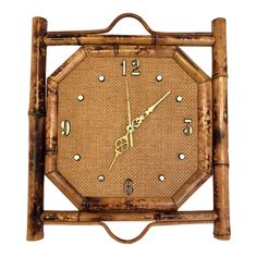 a clock made out of bamboo sticks with gold hands and numbers on the face is shown