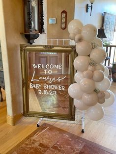 a welcome sign and balloons are hanging in front of a mirror