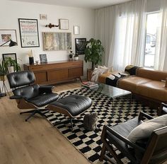 a living room filled with furniture and a cat sitting on top of a black and white rug