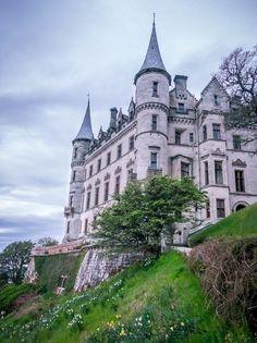 an old castle sitting on top of a lush green hillside