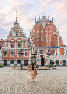 a woman walking in front of a large building