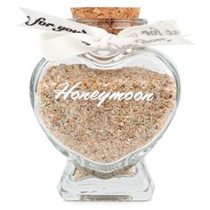 a heart shaped jar filled with sand that says honeymoon