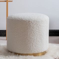 a white stool sitting on top of a fluffy rug