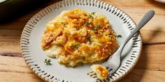 a white plate topped with macaroni and cheese on top of a wooden table