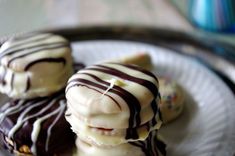 three chocolate covered desserts sitting on top of a white plate