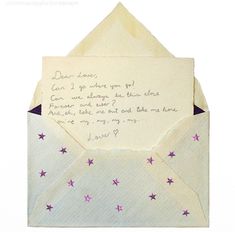 an open envelope with a handwritten note inside it, and stars on the side