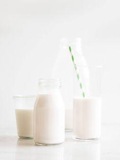 there are two glass bottles with milk next to each other