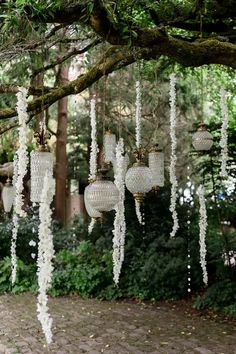 white chandeliers hanging from a tree in the park