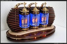 three blue glass jars sitting on top of a wooden stand