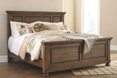 a bed sitting in a bedroom on top of a hard wood floor next to a window