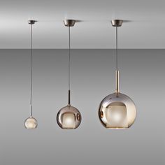 three lights hanging from the ceiling in different shapes and sizes, with one light on each side