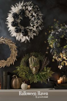 halloween wreaths and other decorations are arranged on a mantle in front of a dark background