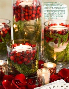 an image of christmas decorations in glass vases with candles on the side and red pomegranates around them