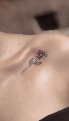 a woman's chest with a rose tattoo on the left side of her breast