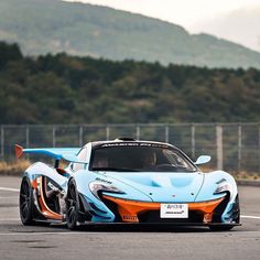 a blue and orange sports car driving on a race track