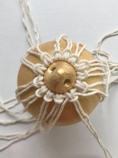 a close up of an object made out of rope and wood with a golden ball on top