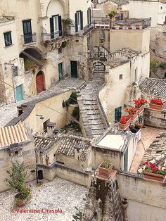 an aerial view of some buildings with red flowers on the windows and balconies