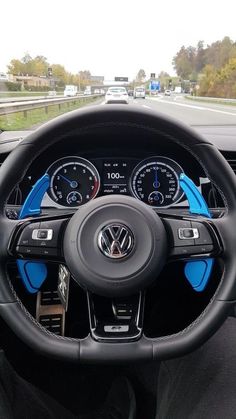 the interior of a car with blue dash lights and steering wheel, dashboard gauges