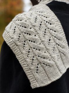 the back of a woman's sweater, with an intricate lace design on it