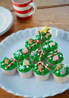 cupcakes are arranged in the shape of a christmas tree on a white plate