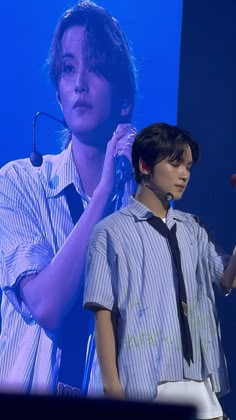 two young men standing next to each other on stage