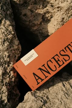 an orange book sitting on top of a rock