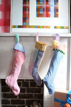 three stockings hanging from a fireplace in front of a fire place