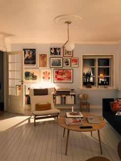 a living room filled with furniture and pictures on the wall