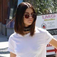 a woman in white shirt and black pants on sidewalk