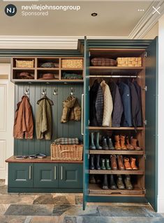 an open closet with shoes and coats hanging on the wall next to a wooden bench