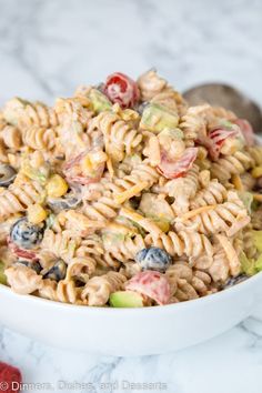 a white bowl filled with pasta salad on top of a table