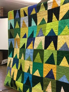 a colorful quilt is hanging on the wall