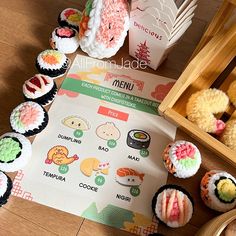 an assortment of sushi and other foods on a wooden table next to a menu