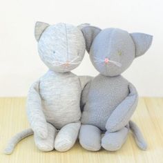 two stuffed cats sitting next to each other on a table