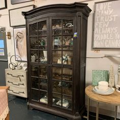 an antique china cabinet with glass doors in a room filled with other furniture and decor