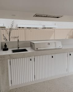 an outdoor kitchen with sink, grill and countertop space in the middle of it