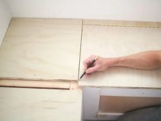 a man is cutting wood with a pair of scissors on top of the countertop